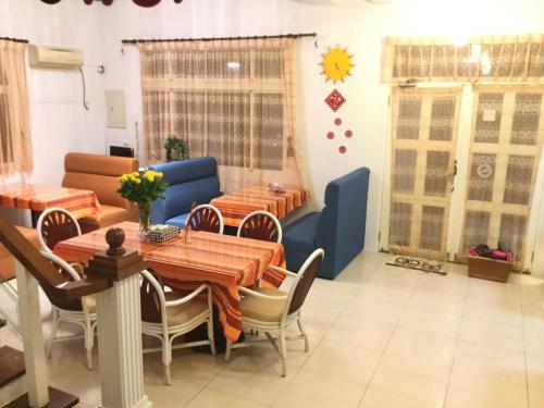 a dining room with a table and a blue couch at Sunny Villa Homestay in Wujie