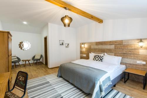 a bedroom with a large bed with a wooden headboard at Drachenhaus Urban Villa in Braşov