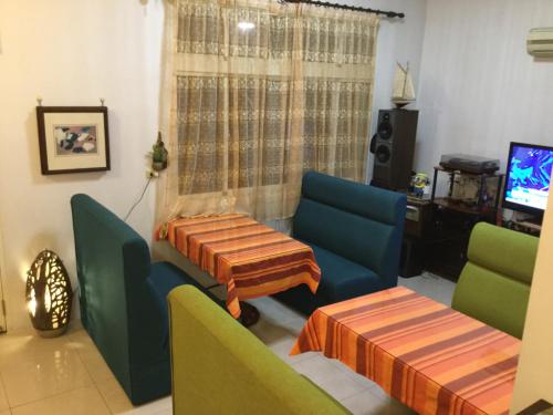 a living room with chairs and a table and a tv at Sunny Villa Homestay in Wujie