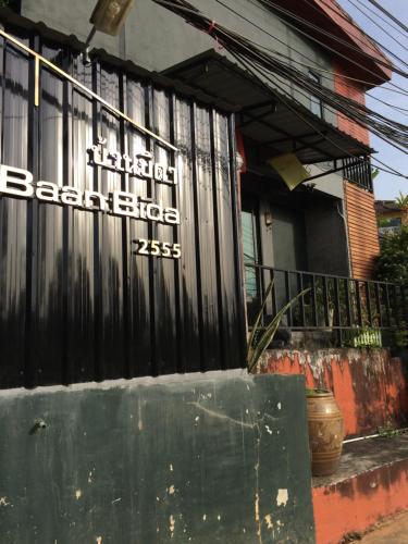 a black fence with a sign on it in front of a house at Baan Bida in Krabi town