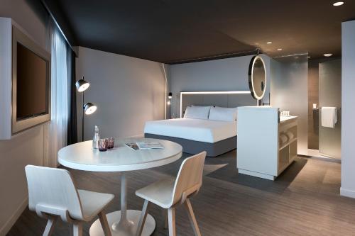 a hotel room with a bed and a table and chairs at INNSiDE by Meliá Paris Charles de Gaulle Airport in Roissy-en-France