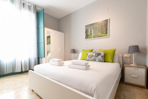 a bedroom with a large white bed with green pillows at Be Barcelona Eixample Urquinaona II in Barcelona