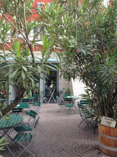 a courtyard with chairs and tables and trees at Hotel Figl ***S in Bolzano