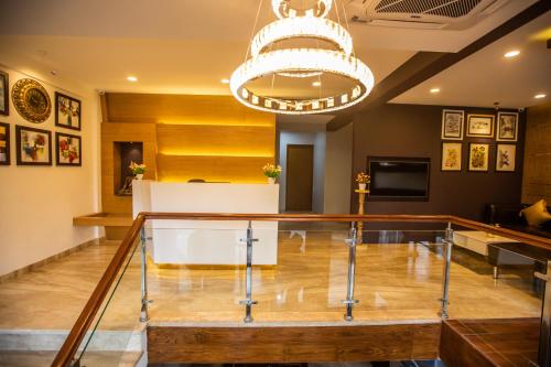 a glass table in a lobby with a chandelier at Hotel Paramos Inn in Bengaluru