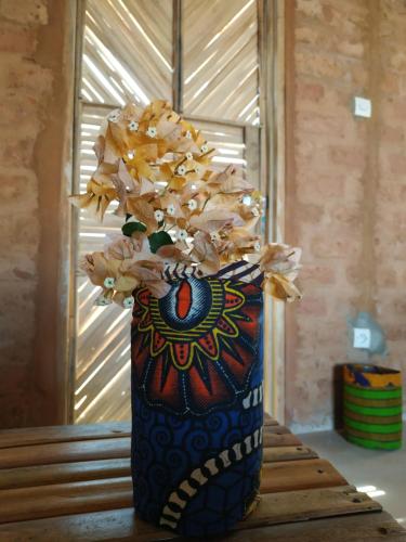 a colorful vase filled with dried flowers on a table at Nguel du Saloum - Chez Abdou et Mar in Mar Lodj