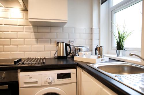 a kitchen with a sink and a dishwasher at Baron View Apartment in Paisley