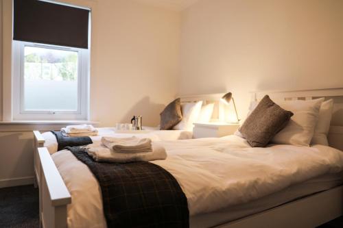 ein Schlafzimmer mit zwei Betten und einem Fenster in der Unterkunft Baron View Apartment in Paisley