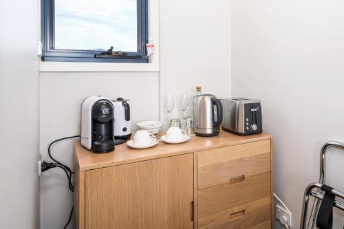 a kitchen with appliances on top of a wooden cabinet at Madsen Retreat in Penguin