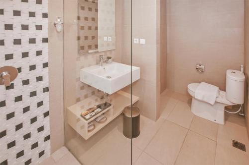 a bathroom with a sink and a toilet at The Azana Hotel Airport Semarang in Semarang