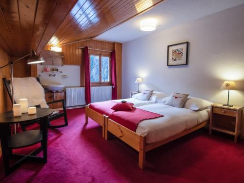 a bedroom with a bed and a table and a chair at Hotel Edelweiss in Nendaz