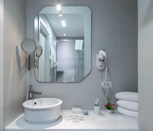 La salle de bains est pourvue d'un lavabo blanc et d'un miroir. dans l'établissement C'era Una Volta, à Palerme