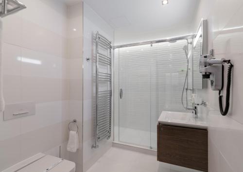 a bathroom with a shower and a toilet and a sink at Spa Hotel ULRIKA in Karlovy Vary