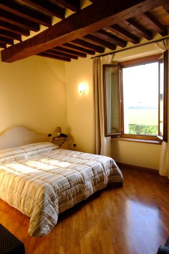 a bedroom with a bed and a large window at Agriturismo Corte Palazzo in Marcaria