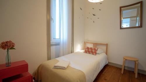 リスボンにあるComfy @ Chiadoのベッドルーム1室(ベッド1台付)、壁に鳥が描かれた窓が備わります。