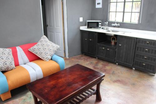 a living room with a couch and a table at Soul Village Farm Self Catering Retreat in Hekpoort