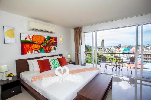 ein Schlafzimmer mit einem großen Bett und einem Balkon in der Unterkunft Wazza's Patong Apartment, Smart TV and Fast Wi-Fi in Patong Beach