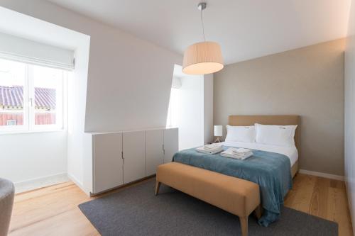 um quarto com uma cama, uma cadeira e uma janela em FLH Chiado Bright Apartment em Lisboa