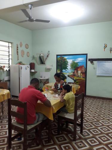 eine Gruppe von Menschen, die an einem Tisch sitzen in der Unterkunft Hotel Shangri-la in Três Corações