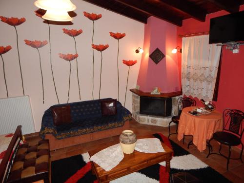 a living room with a couch and flowers on the wall at Mountain Ηouse in Arcadia in Vytina