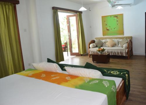 a room with two beds and a couch in it at Muthu Nila villa- Mirissa in Mirissa
