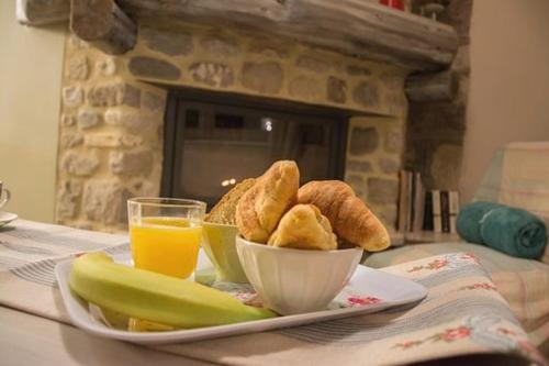 a plate of food with bread and a glass of orange juice at 1957 To Rodo kai to Roido in Karpenision
