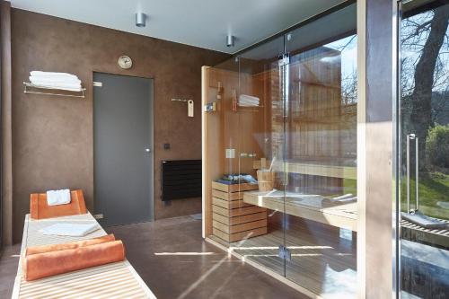 a bathroom with a glass shower and a bench at B&B Park7 Wavre - Leuven in Huldenberg