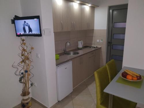 a kitchen with a sink and a tv on a wall at De Lux Apartments Luka in Bar