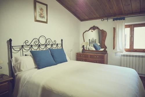 um quarto com uma cama grande e um espelho em Casa rural rincón de Letur em Letur