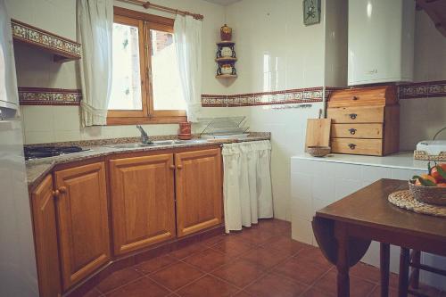 cocina con armarios de madera, fregadero y ventana en Casa rural rincón de Letur, en Letur