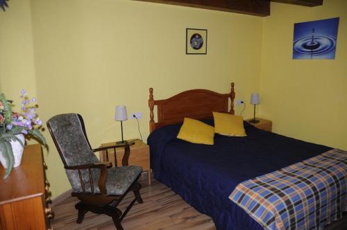 1 dormitorio con 1 cama y 1 silla en La Cabaña, en Canfranc