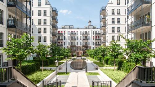 a courtyard in a city with tall buildings at The Wellem Residences in Düsseldorf