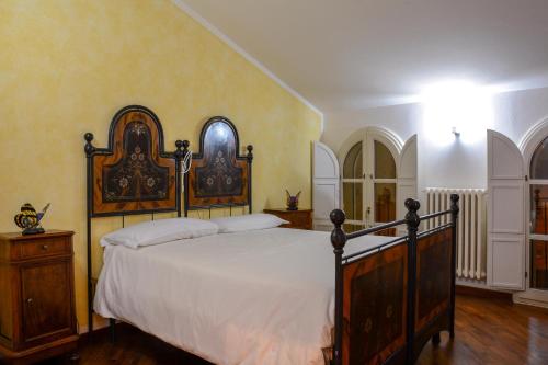 a bedroom with a large bed with white sheets at Locanda Al Portone in Scandiano