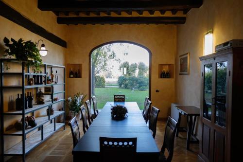 comedor con mesa y sillas y ventana grande en Agriturismo Corte Palazzo, en Marcaria