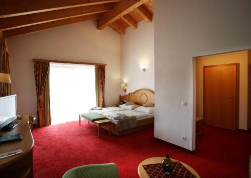 a bedroom with a bed and a large window at Aktiv- und Wellnesshotel Gutjahr in Abtenau