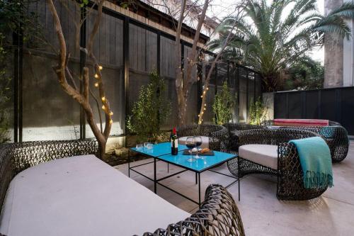 a patio with chairs and a table with at Apart Hotel B in Santiago