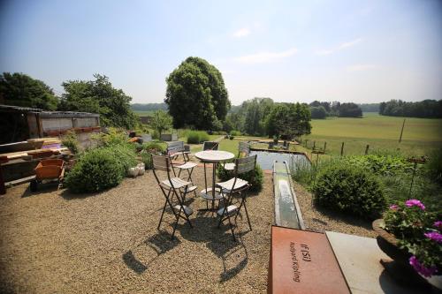 a patio with a table and chairs in a garden at Barsy 34 in Havelange