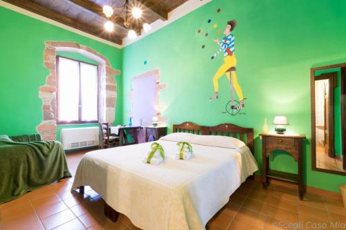 a bedroom with two beds and a painting of a man jumping at B&B S'Asilo Sardegna in Banari