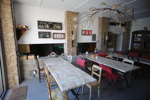 a restaurant with wooden tables and chairs and a bar at Barsy 34 in Havelange
