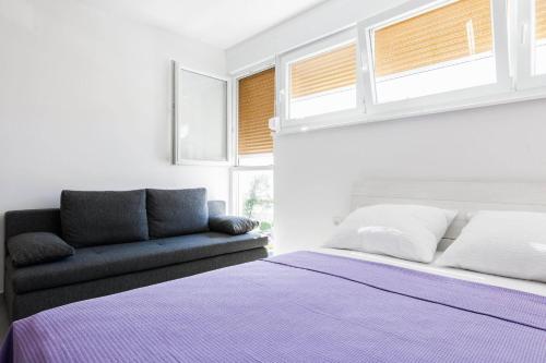 - une chambre avec un lit et un canapé dans l'établissement Stylish Centre Apartments, à Zadar