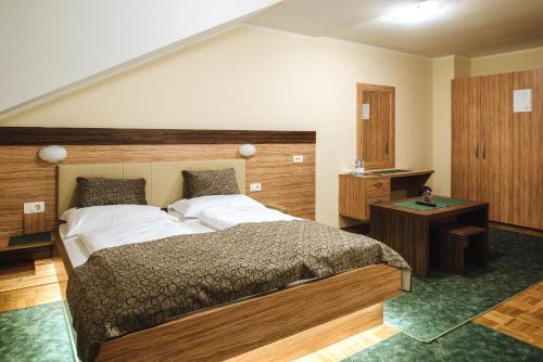 a bedroom with a large bed with a wooden headboard at Gostisce Ulipi in Slovenske Konjice