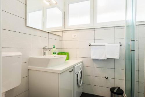La salle de bains blanche est pourvue d'un lavabo et de toilettes. dans l'établissement Stylish Centre Apartments, à Zadar