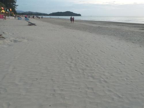 a group of people walking on the beach at Lanta Blue House in Ko Lanta