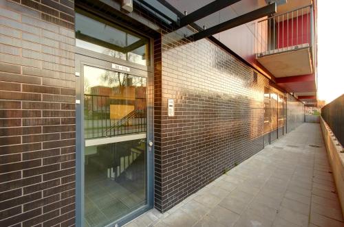 an empty hallway of a brick building with a glass door at Kauno-Algirdo Luxury apartments in Vilnius