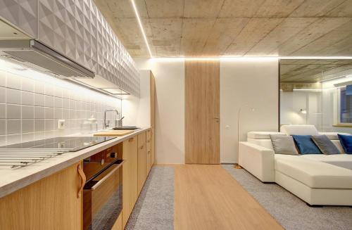 a kitchen and a living room with a couch at Kauno-Algirdo Luxury apartments in Vilnius