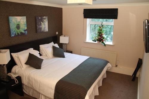 a bedroom with a large bed with a christmas tree on the window at Greenvale Hotel in Cookstown