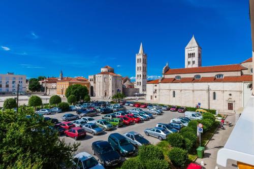 a parking lot with cars parked in front of a building at Stylish Centre Apartments in Zadar