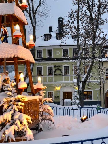 a building covered in snow with a gazebo at Aparthotel Deutscher Kaiser Ferienwohnungen in Kurort Oberwiesenthal