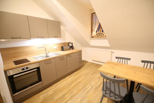 a kitchen with a sink and a table with a dining room at Aparthotel Deutscher Kaiser Ferienwohnungen in Kurort Oberwiesenthal