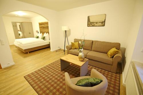 a living room with a couch and a table at Aparthotel Deutscher Kaiser Ferienwohnungen in Kurort Oberwiesenthal