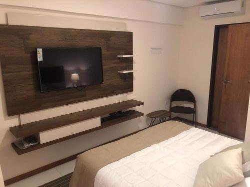 a hotel room with a bed and a flat screen tv at Centro de Asunción Nuevo Apartamento, Cómodo, Seguro, Piscina, Gimnasio y Parking in Asuncion